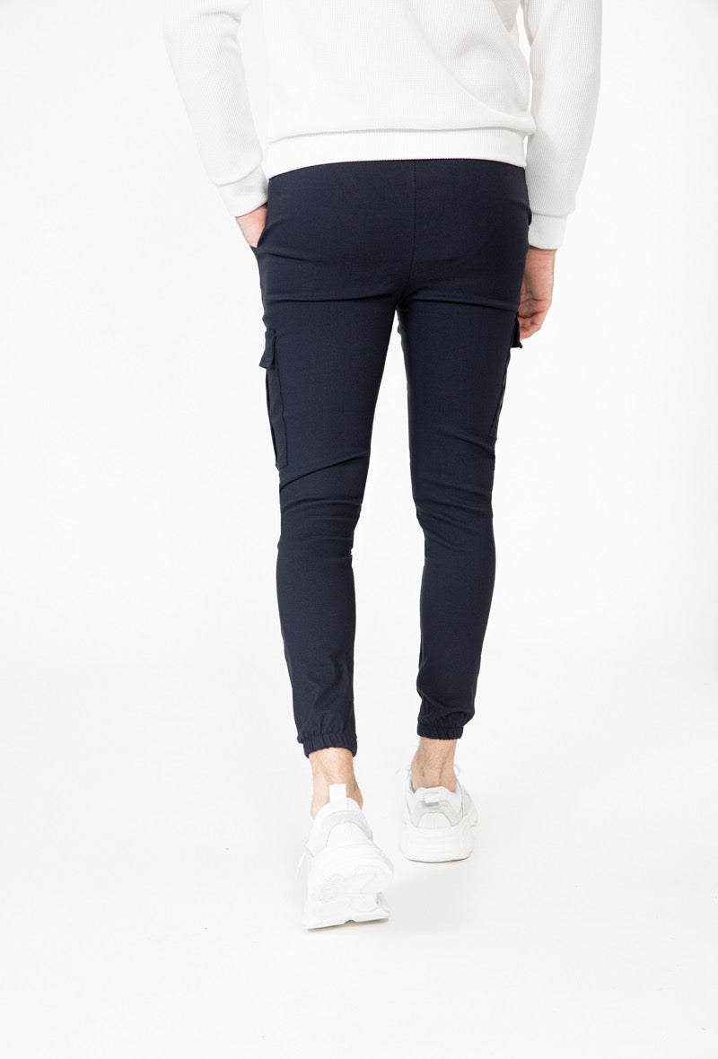 Achteraanzicht van marineblauwe cargo broek met elastische enkels.