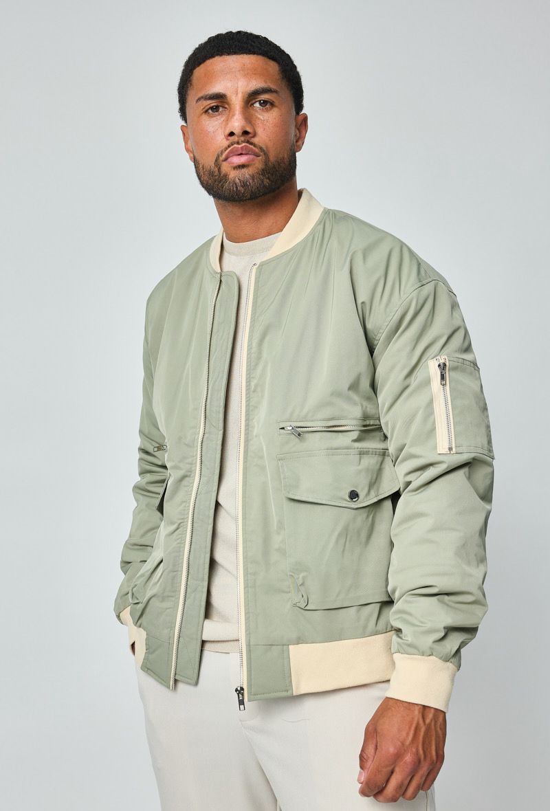 Herenmodel met groene bomberjack, licht gedraaid naar links voor een driekwartaanzicht.