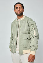 Herenmodel met groene bomberjack, licht gedraaid naar links voor een driekwartaanzicht.