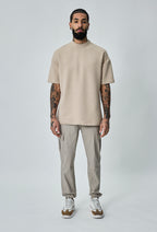 Model draagt beige heren cargo broek met cargozakken en beige shirt – volledig vooraanzicht.