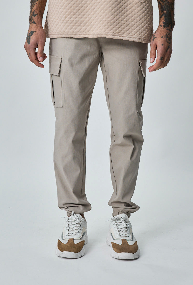 Beige heren cargo broek met cargozakken, recht model, gedragen door model – vooraanzicht.