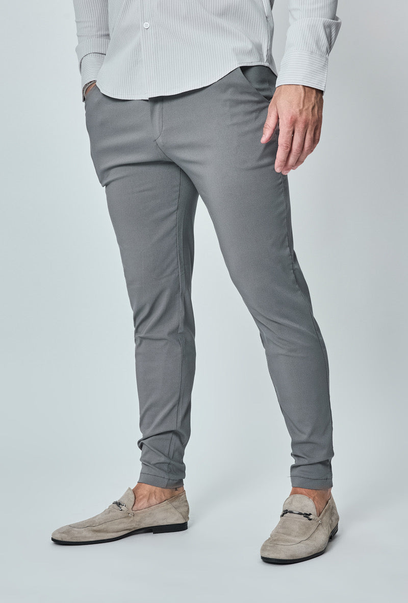 Slanke donkergrijze heren chino broek, model met handen in zakken, frontaal zichtbaar