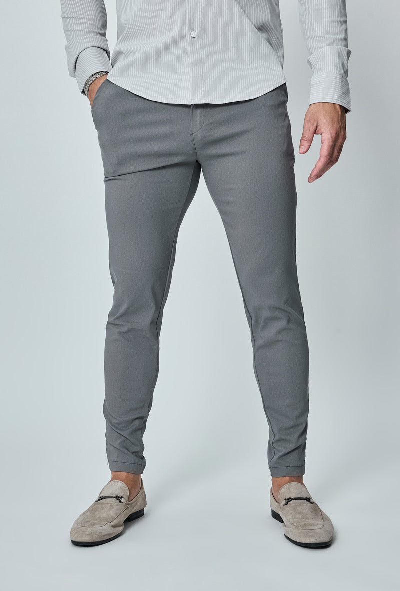 Donkergrijze slim fit chino broek, volledig frontaan gedragen door model.