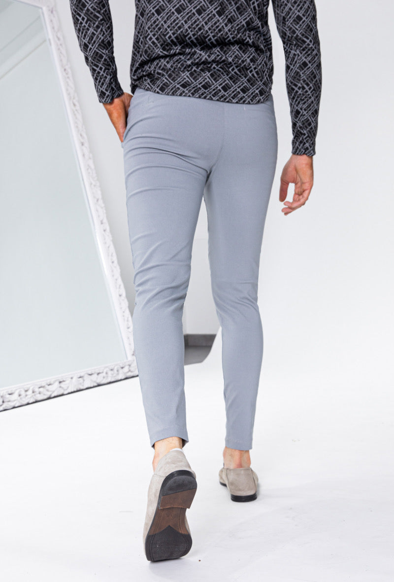 Achteraanzicht van lichtgrijze slim fit chino broek tijdens het lopen.