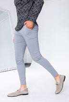Lichtgrijze slim fit chino broek gedragen door man in lopende zijaanzicht pose.