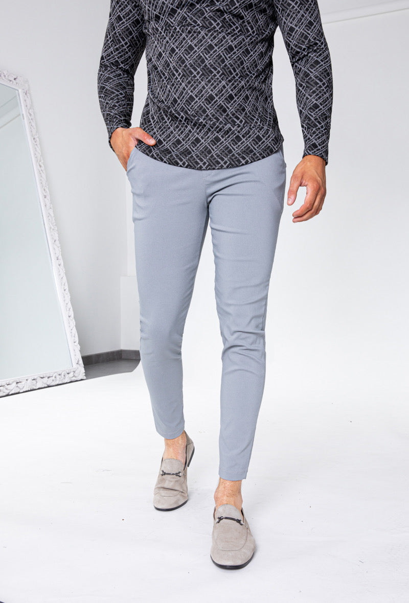 Man draagt lichtgrijze slim fit chino broek gecombineerd met donker shirt, frontaal aangezicht.