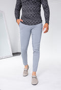 Man draagt lichtgrijze slim fit chino broek gecombineerd met donker shirt, frontaal aangezicht.
