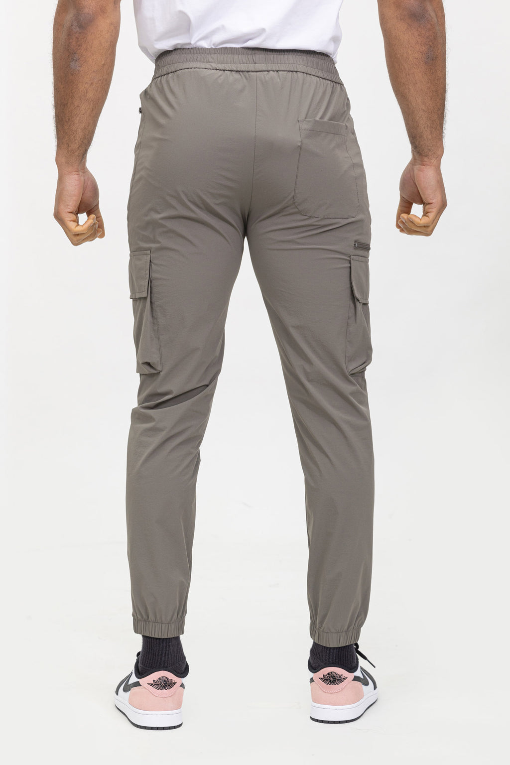 Achteraanzicht van taupe jogger cargo broek met elastische tailleband en rechte pasvorm.
