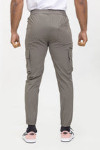 Achteraanzicht van taupe jogger cargo broek met elastische tailleband en rechte pasvorm.