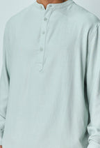 Close-up van lichtblauw linnen overhemd met Mao-kraag en knoopsluiting