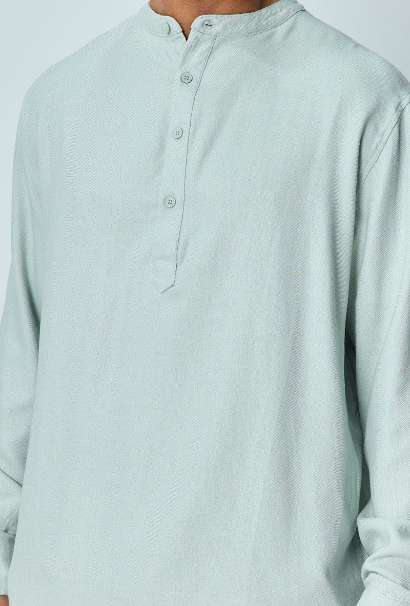 Close-up van lichtblauw linnen overhemd met Mao-kraag en knoopsluiting