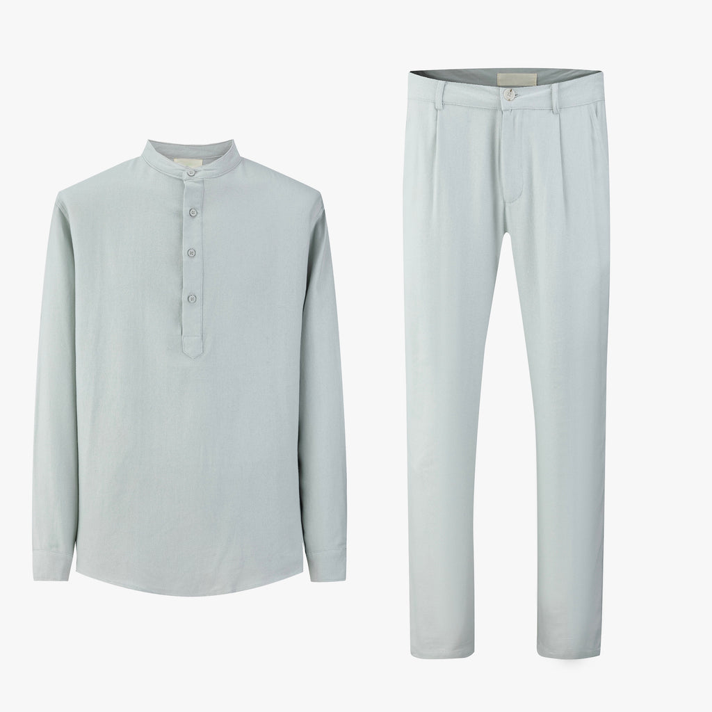 Lichtblauwe linnen set bestaande uit overhemd met Mao-kraag en rechte broek, plat neergelegd.