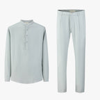 Lichtblauwe linnen set bestaande uit overhemd met Mao-kraag en rechte broek, plat neergelegd.