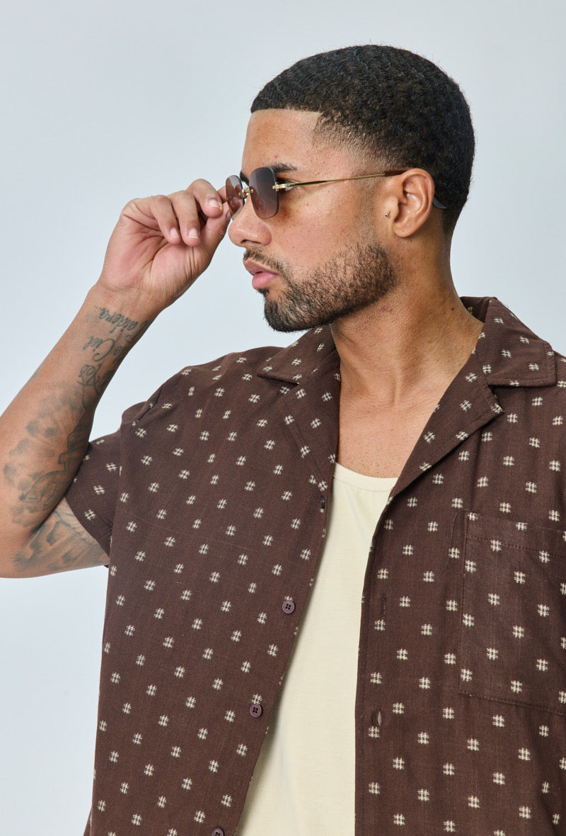 Man met goudkleurige randloze zonnebril met bruin gradient glazen – close-up zijaanzicht.