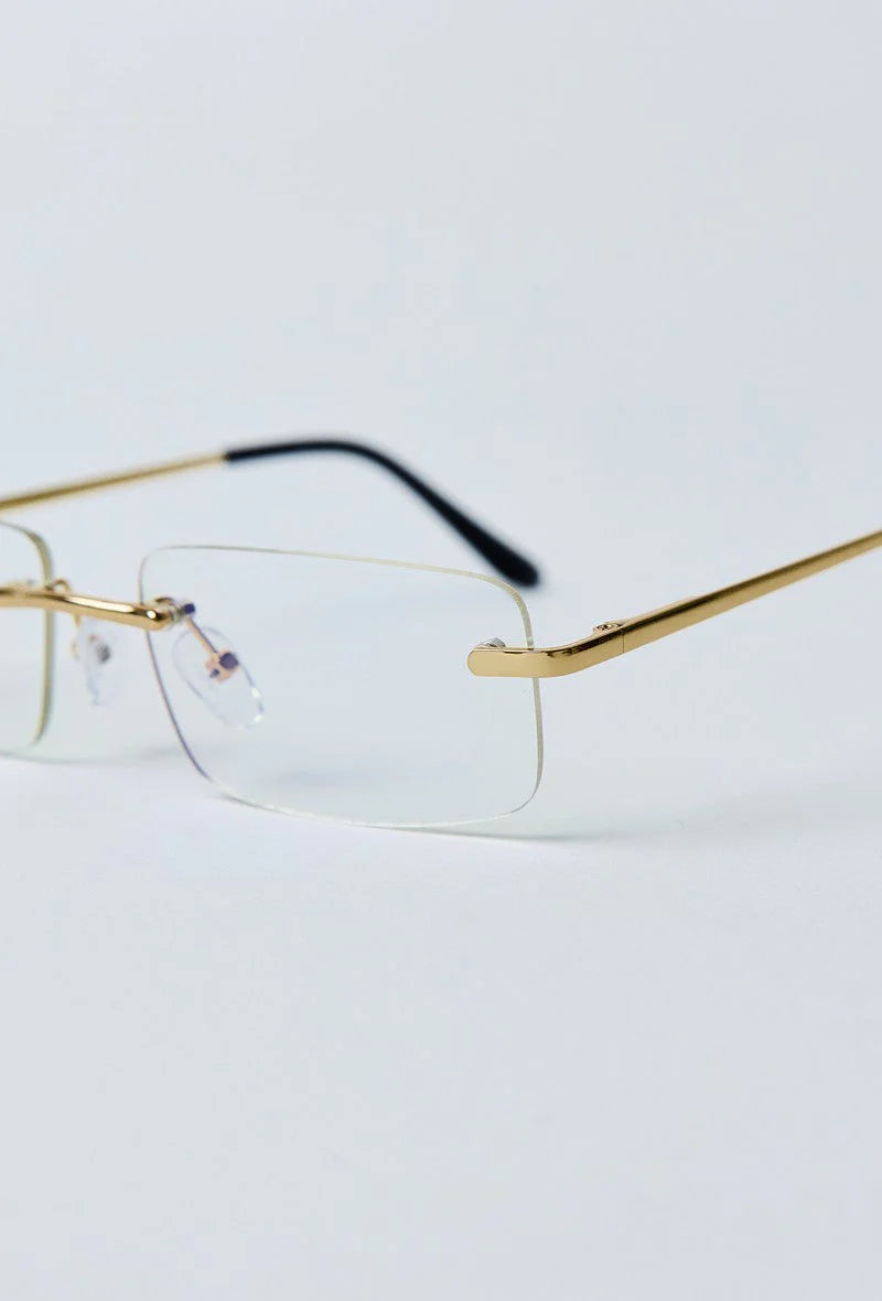 Close-up van gouden pootjes en transparant frame van randloze zonnebril