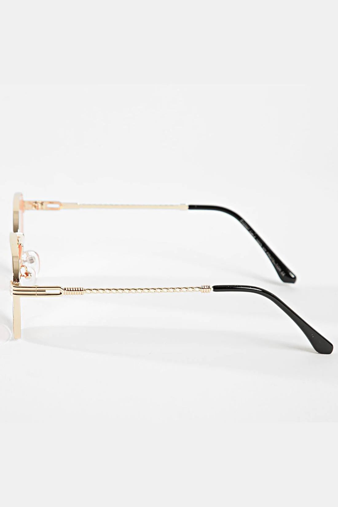 Zijkant van lichtblauwe zonnebril met dun goud frame en zwarte pootjes